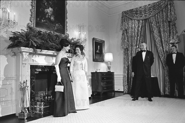 Lady Bird Johnson and Princess Margaret of Great Britain pose in front of fireplace, U.S. President Lyndon Johnson and Antony Armstrong Jones (partially obscured behind Johnson) looking on, Queen's Room, White House, Washington, D.C., USA, Yoichi Okamoto, November 17, 1965