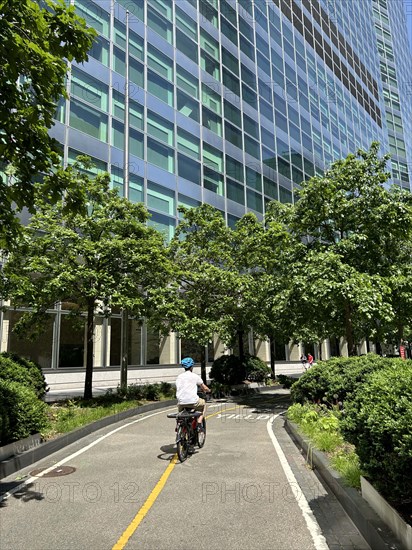 Cyclist on bicycle path alongside Goldman Sachs Global Headquarters, 200 West Street, New York City, New York, USA