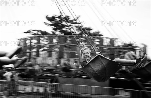 Smiling boy on swing ride at amusement park