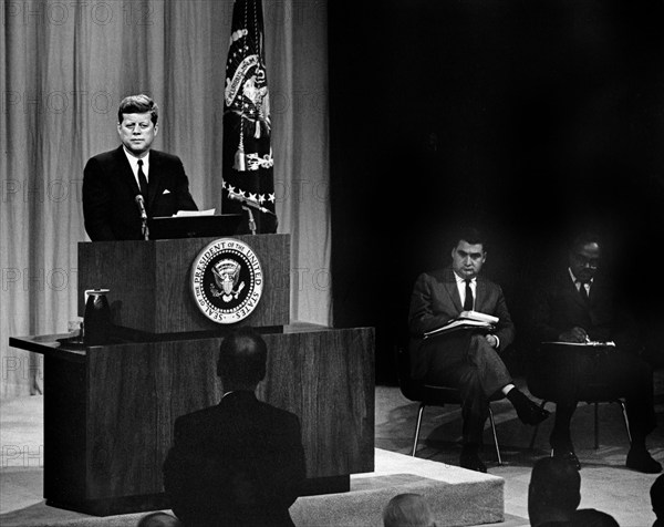 U.S. President John F. Kennedy at lectern during press conference, Press Secretary Pierre Salinger and Associate Press Secretary Andrew Hatcher sit onstage at right, U.S. State Department Auditorium, Washington, D.C., USA, Abbie Rowe, White House Photographs, October 11, 1961