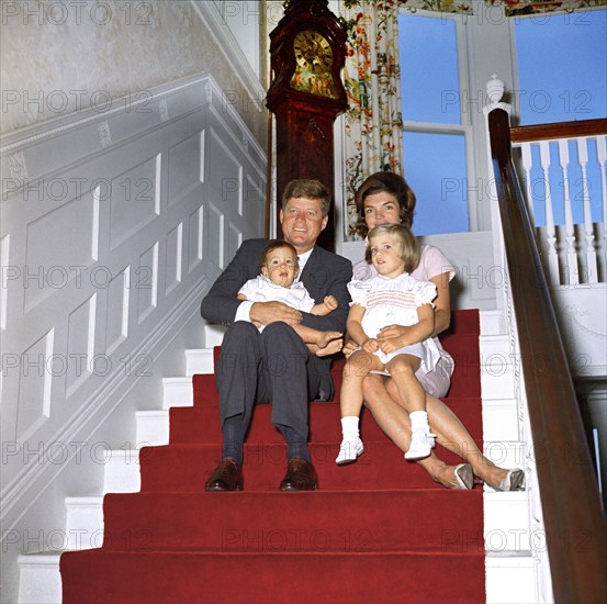 U.S. President John Kennedy and First Lady Jacqueline Kennedy sit with their children, John Kennedy, Jr. and Caroline Kennedy, on stairs inside Auchincloss home at Hammersmith Farm, Newport, Rhode Island, USA, Robert Knudsen, White House Photographs, September 29, 1961