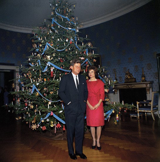 U.S. President John F. Kennedy and U.S. First Lady Jacqueline Kennedy standing in front of Christmas tree in the Blue Room, White House, Washington, D.C., USA, Robert Knudsen, White House Photographs, December 13, 1961