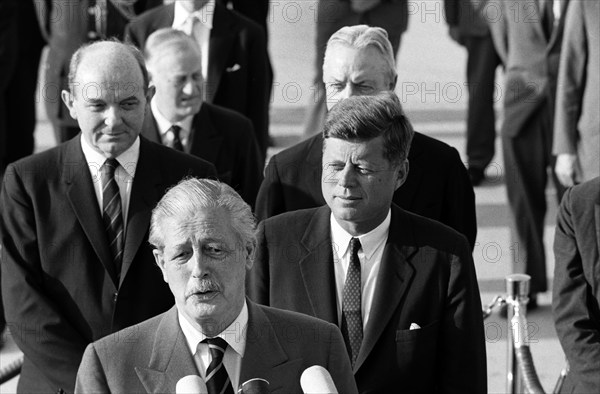 British Prime Minister Harold Macmillan delivering remarks during arrival ceremonies in his honor, Left to right behind MacMillan: Dean Rusk, U.S. Secretary of State; Sir Norman Brook, Secretary of the Prime Minister’s Cabinet; U.S. President John F. Kennedy; David K. E. Bruce, U.S. Ambassador to Great Britain; Andrews Air Force Base, Prince George's County, Maryland, USA, Cecil Stoughton, White House Photographs, April 27, 1962