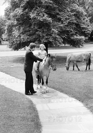 U.S. President John Kennedy with his daughter Caroline Kennedy and Caroline's pony, Macaroni, South Lawn pathway, White House, Washington, D.C., USA, Robert Knudsen, White House Photographs, June 22, 1962