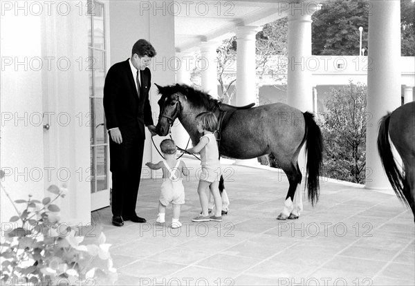 U.S. President John Kennedy and his children, John Kennedy, Jr., and Caroline Kennedy, standing beside Caroline's pony, Macaroni, West Wing Colonnade, White House, Washington, D.C., USA, Robert Knudsen, White House Photographs, June 22, 1962