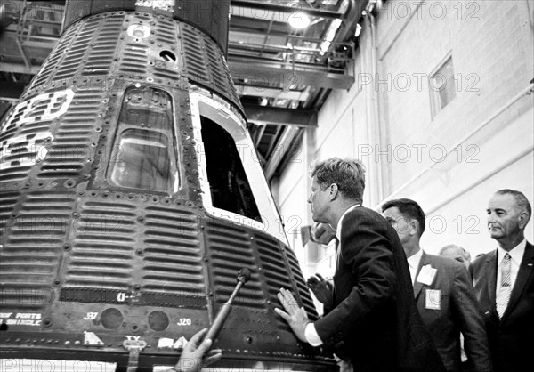 U.S. President John F. Kennedy and U.S. Vice President Lyndon Johnson (background, right) inspecting Mercury spacecraft capsule #19, during a tour of Mercury systems and equipment inside Hangar S, Cape Canaveral Air Force Station, Cape Canaveral, Florida, USA, Cecil Stoughton, White House Photographs, September 11, 1962