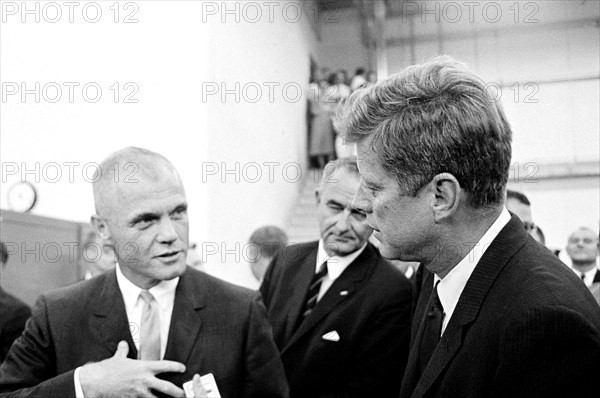 U.S. President John F. Kennedy visiting with astronaut Lieutenant Colonel John H. Glenn, Jr. (left), during tour of spacecraft displays, U.S. Vice President Lyndon B. Johnson in background, Rich Building, Manned Spacecraft Center, Houston, Texas, USA, Cecil Stoughton, White House Photographs, September 12, 1962