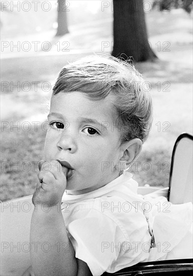 John Kennedy, Jr., sucking his finger while sitting in carriage on South Lawn, Washington, D.C., USA, Cecil Stoughton, White House Photographs, May 17, 1962