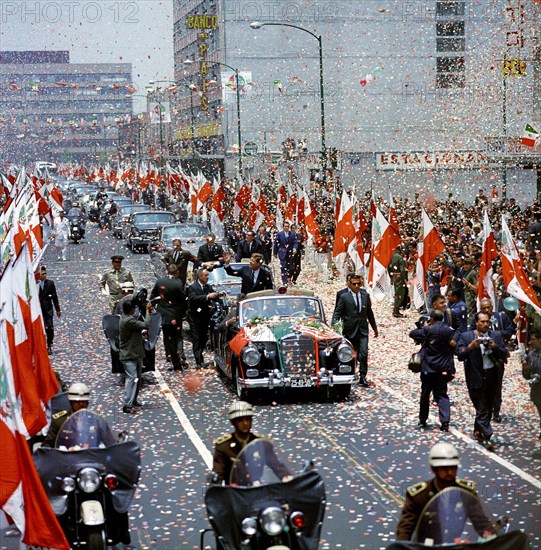 U.S. President John F. Kennedy waving to crowd from convertible car as confetti falls during motorcade to Los Pinos, the official residence of the President of Mexico, Mexico City, Mexico, Robert Knudsen, White House Photographs, June 29, 1962