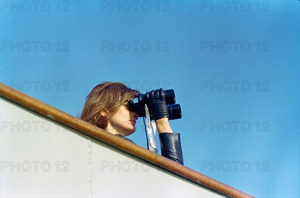 U.S. First Lady Jacqueline Kennedy watching through binoculars fourth  race of America's Cup from aboard USS Joseph P. Kennedy, Jr., Newport, Rhode Island, USA, Cecil Stoughton, White House Photographs, September 22, 1962