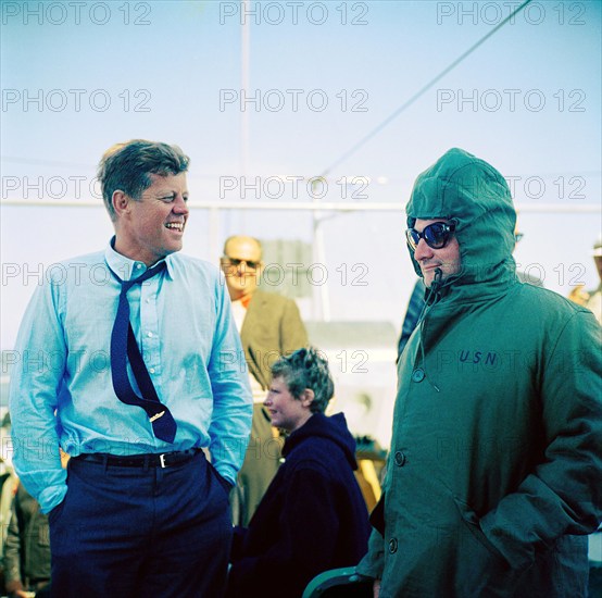 U.S. President John F. Kennedy (wearing a PT-109 pin on his tie) laughing with Press Secretary Pierre Salinger (right) during fourth race of America's Cup from aboard USS Joseph P. Kennedy, Jr., Newport, Rhode Island, USA, Cecil Stoughton, White House Photographs, September 22, 1962