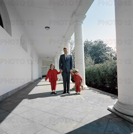 U.S. President John F. Kennedy walking with his children, Caroline Kennedy and John F. Kennedy, Jr., along the West Wing Colonnade, White House, Washington, D.C., USA, Cecil Stoughton, White House Photographs, March 28, 1963