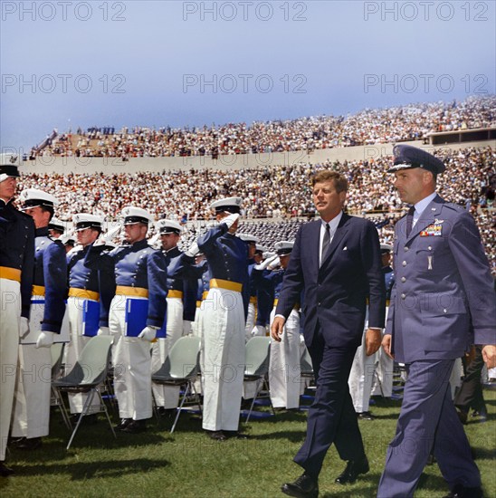 U.S. President John F. Kennedy and Major General Robert H. Warren walking past saluting cadets while attending commencement exercises for the fifth graduating class, Falcon Stadium, U.S. Air Force Academy, Colorado Springs, Colorado, USA, Robert Knudsen, White House Photographs, June 5, 1963