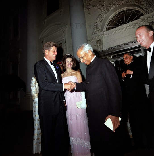 President of India, Dr. Sarvepalli Radhakrishnan, shaking hands with U.S. President John F. Kennedy as U.S. First Lady Jacqueline Kennedy looks on following state dinner in his honor, North Portico, White House, Washington, D.C., USA, Cecil Stoughton, White House Photographs, June 3, 1963