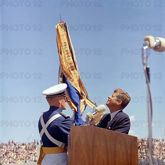 U.S. President John F. Kennedy receiving U.S. Air Force Academy ceremonial flag from unidentified cadet during commencement exercises for the fifth graduating class, Falcon Stadium, U.S. Air Force Academy, Colorado Springs, Colorado, USA, Robert Knudsen, White House Photographs, June 5, 1963