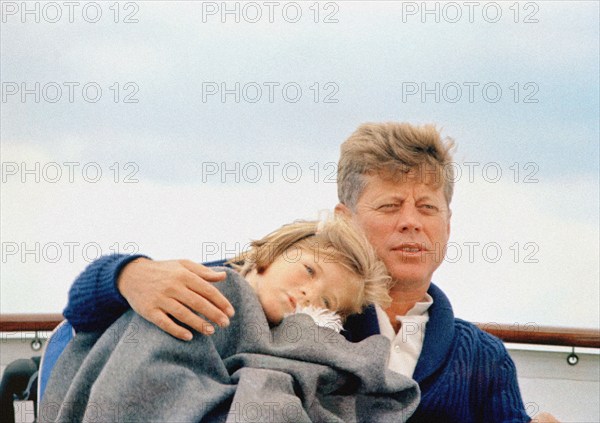 U.S. President John F. Kennedy sitting with his arm around his daughter, Caroline Kennedy, aboard the Presidential yacht, “Honey Fitz,” off the coast of Hyannis Port, Massachusetts, USA, Cecil Stoughton, White House Photographs, August 25, 1963