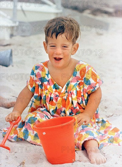 John F. Kennedy, Jr. son of U.S. President John F. Kennedy and U.S. First Lady Jacqueline Kennedy, sitting with pail and shovel at beach, Hyannis Port, Massachusetts, USA, Cecil Stoughton, White House Photographs, August 25, 1963