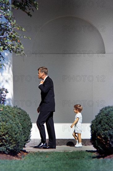 U.S. President John F. Kennedy walking with his son, John F. Kennedy, Jr., along West Wing Colonnade of White House, Washington, D.C., USA, Robert Knudsen, White House Photographs, October 10, 1963