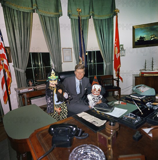 U.S. President John F. Kennedy visiting with his children, Caroline Kennedy (left, holding cat) and John F. Kennedy, Jr., both in Halloween costumes, Oval Office, White House, Washington, D.C., USA, Cecil Stoughton, White House Photographs, October 31, 1963