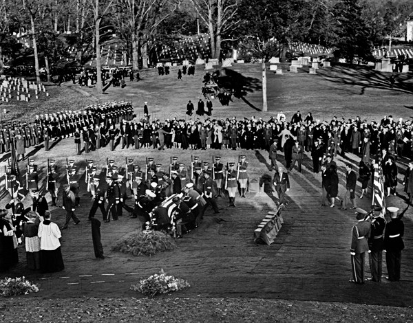 Kennedy family members: U.S. Attorney General Robert F. Kennedy, Jacqueline Kennedy, U.S. Senator Edward M. Kennedy, Rose Fitzgerald Kennedy, Steven Smith, Peter Lawford, Jean Kennedy Smith, Eunice Kennedy Shriver, follow as Honor guard pallbearers place the flag-draped casket of U.S. President John F. Kennedy at gravesite, during graveside services in the state funeral of President Kennedy, Arlington National Cemetery, Arlington, Virginia, USA, Abbie Rowe, White House Photographs, November 25, 1963