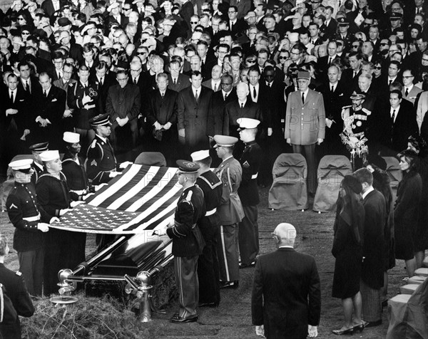 Members of the Kennedy family, officials, and dignitaries look on as honor guard pallbearers lift casket flag of U.S. President John F. Kennedy at gravesite, during graveside services in the state funeral of President Kennedy, Arlington National Cemetery, Arlington, Virginia, USA, Abbie Rowe, White House Photographs, November 25, 1963