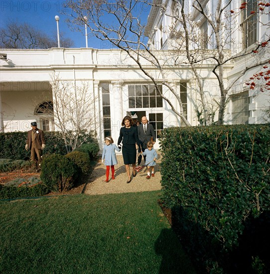 Former U.S. First Lady, Jacqueline Kennedy, and her children, Caroline Kennedy and John F. Kennedy, Jr., departing White House through the Rose Garden for the last time with Special Assistant to U.S. President John F. Kennedy, Dave Powers, following behind, Washington, D.C., USA, Cecil Stoughton, White House Photographs, December 6, 1963