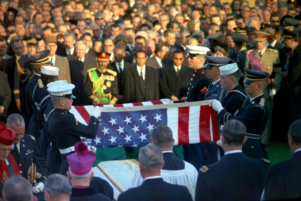 Officials and foreign dignitaries look on as honor guard pallbearers fold the casket flag during graveside services in the state funeral of President John F. Kennedy, Arlington National Cemetery, Arlington, Virginia, USA, Cecil Stoughton, White House Photographs, November 25, 1963