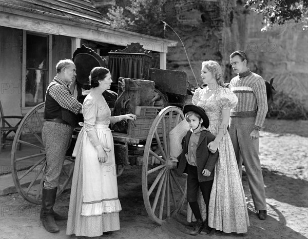 Scotty Beckett (small boy), Virginia Bruce (2nd right), Dennis O'Keefe (right), on-set of the western film, "The Bad Man Of Brimstone", Loew's Inc., 1937