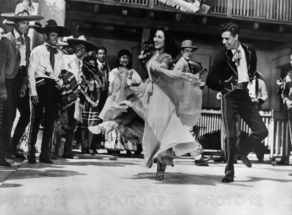 Elena Verdugo, Rian Valente (both dancing), on-set of the western film, "The Big Sombrero", Columbia Pictures, 1949