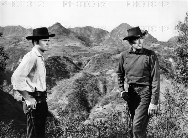 Barry Coe (left), Gregory Peck (right), on-set of the western film, "The Bravados", 20th Century-Fox, 1958