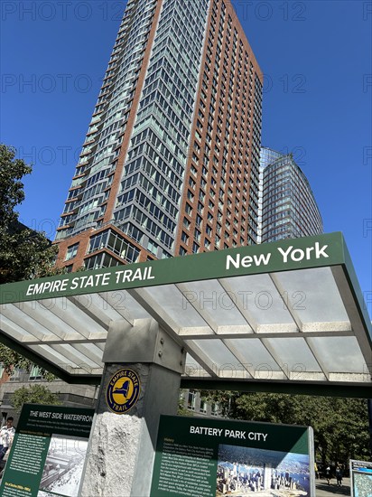 Low angle view of residential skyscraper and information kiosk for Empire State Trail, Battery Park City, New York City, New York, USA