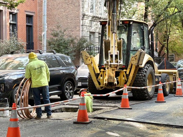 Infrastructure maintenance worker with excavator, street scene, Greenwich Village, New York City, New York, USA