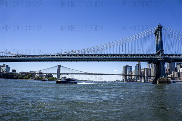 Manhattan (foreground) and Brooklyn (background) bridges crossing over East River with downtown Manhattan skyline in background (right), New York City, New York, USA