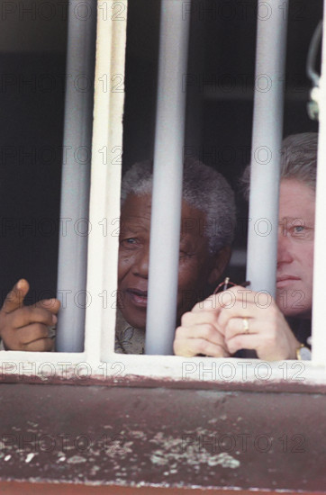 U.S. President Bill Clinton and South African President Nelson Mandela looking out from Cell Block B prison bars, Robben Island, South Africa, Sharon Farmer, White House Photograph Office, March 27, 1998