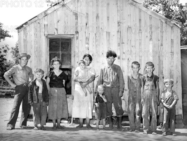 Family of agricultural day laborer standing in front of their two-room shack, McIntosh County, Oklahoma, USA, Russell Lee, U.S. Farm Security Administration, June 1939