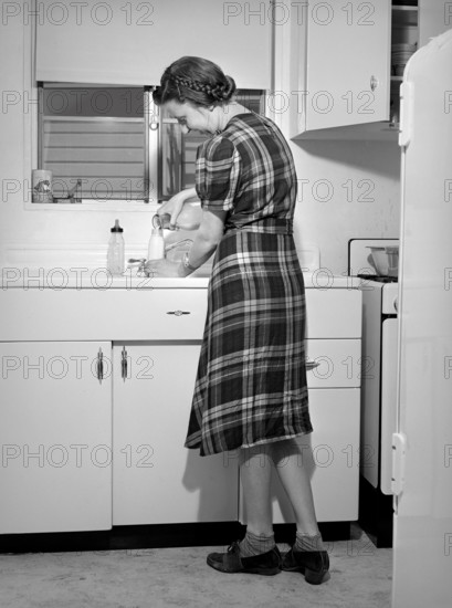 Mother preparing baby's bottle, Kearny Mesa defense housing project, San Diego, California, USA, Russell Lee, U.S. Farm Security Administration, May 1941