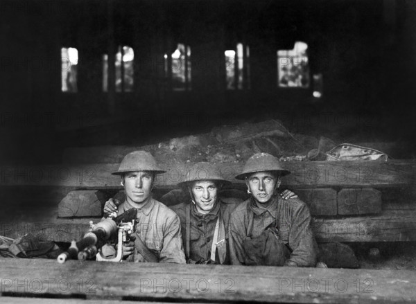 Three U.S. soldiers with machine gun set up in railroad shop, Company A, Ninth Machine Gun Battalion, Chateau-Thierry, France, U.S. Army Signal Corps, June 7, 1918