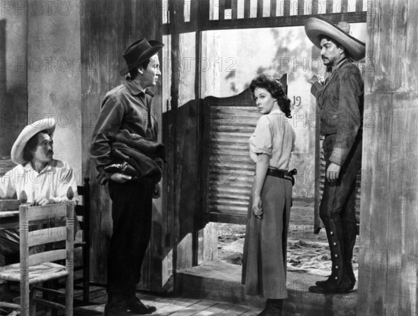 Cameron Mitchell (standing left), Susan Hayward, Victor Manuel Mendoza (standing right),  on-set of the western film, "Garden Of Evil", 20th Century-Fox, 1954