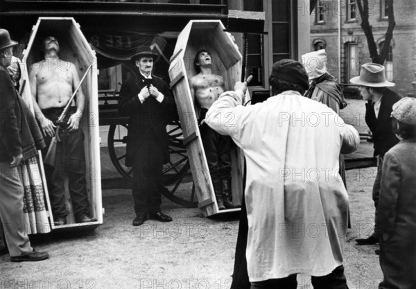 R.G. Robinson (left coffin), Craig Curtis (right coffin), Mel Yoder (undertaker), on-set of the western film, "The Great Northfield, Minnesota Raid", Universal Pictures, 1972