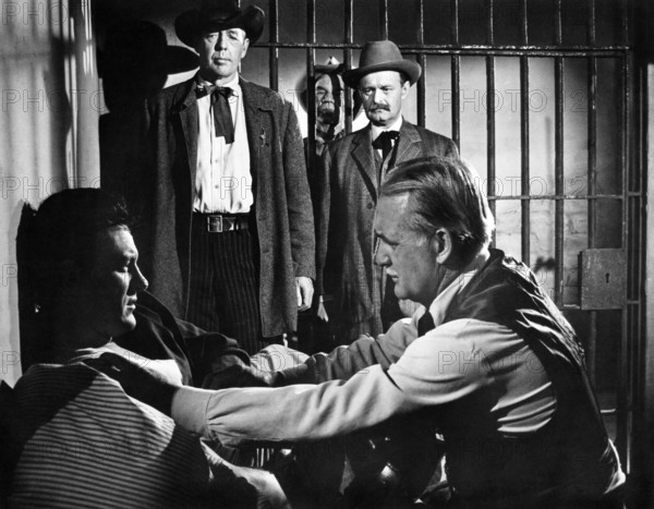 James Arness (foreground left), Frank Fenton (standing left), George DeNormand (foreground right), on-set of the western film, "Gun The Man Down", United Artists, 1956