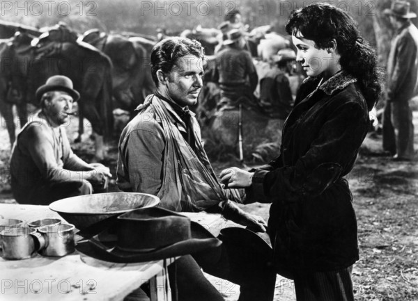 Jesse White (left), Audie Murphy (center), Susan Cabot (right), on-set of the western film, "Gunsmoke", Universal Pictures, 1953