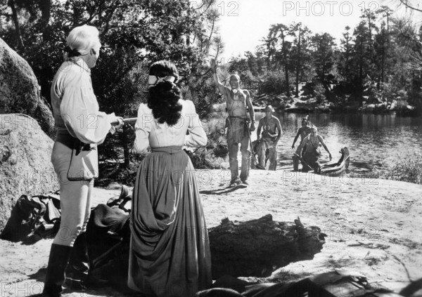 Glen Langan (rear view, left), Brenda Marshall (rear view, 2nd left), on-set of the western film, "The Iroquois Trail", United Artists, 1950