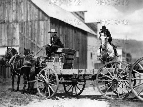 Fred Thomson (jumping over wagon on horse), on-set of the silent western film, "Jesse James", Paramount Pictures, 1927