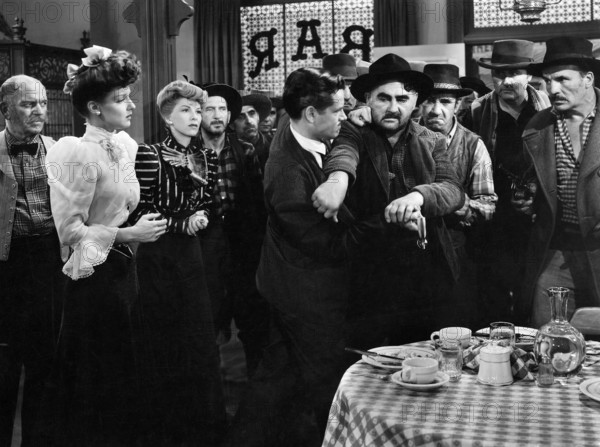 Ann Savage (2nd left), Constance Worth (3rd left), Tom Neal (center profile), on-set of the western film, "Klondike Kate", Columbia Pictures, 1943