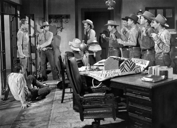 Rex Allen (standing left), Michael Hall (standing 2nd left),  Stan Jones (sheriff), on-set of the western film, "The Last Musketeer", Republic Pictures, 1952