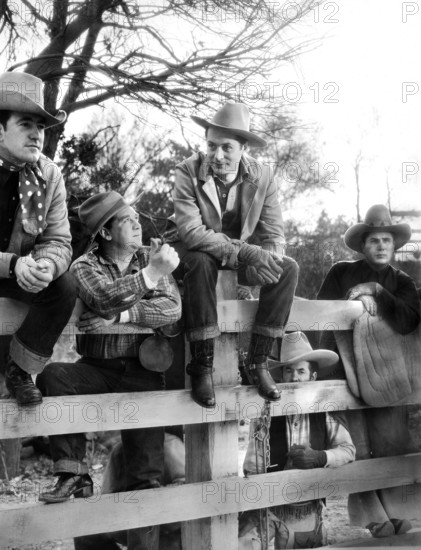 Robert Montgomery (center, sitting on fence), on-set of the western film, "Lovers Courageous", MGM, Loew's Inc., 1932