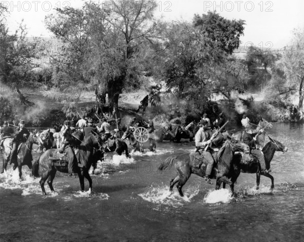 Union soldiers on horseback crossing river, on-set of the western film, "Major Dundee", Columbia Pictures, 1965