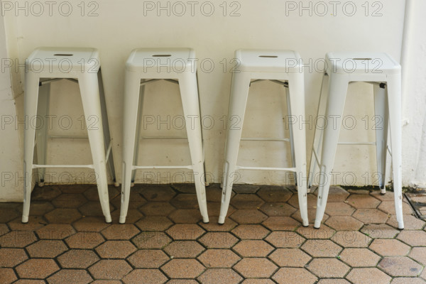 Four white metal stools