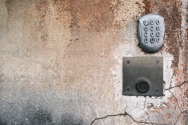 Metal numeric entryway keypad on textured wall