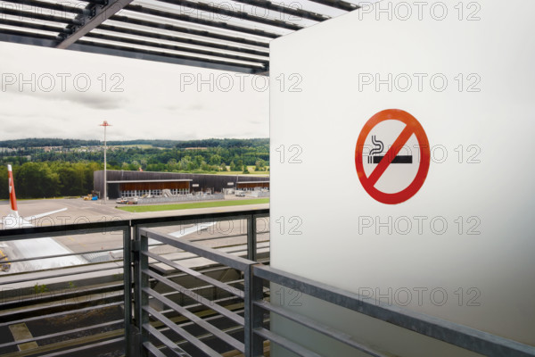 No smoking sign on white wall at airport, Zurich, Switzerland